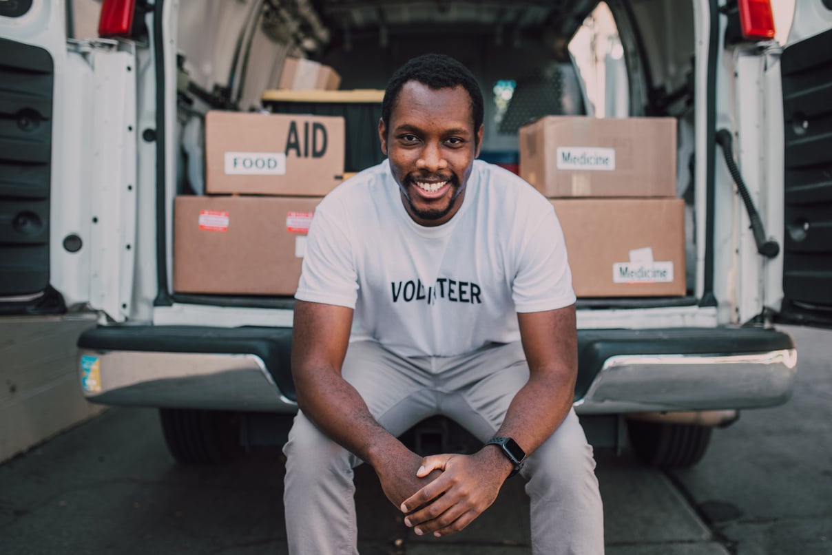 A Man Sitting at the Back of a White Van